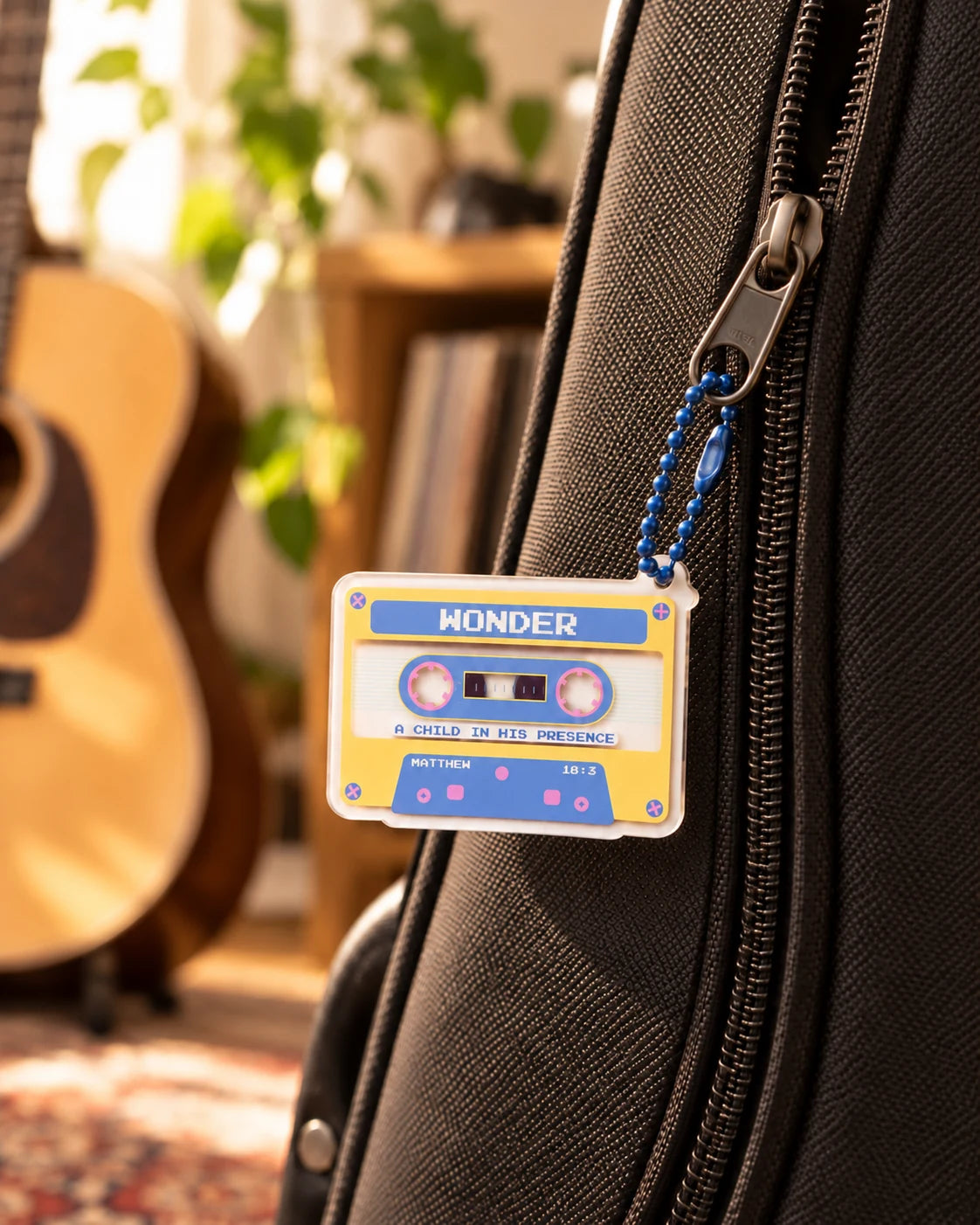 Cassette Tape A Child in His Presence acrylic keychain hanging from a guitar case
