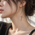 Delicate black Christian cross temporary tattoo applied to the side of a woman's neck
