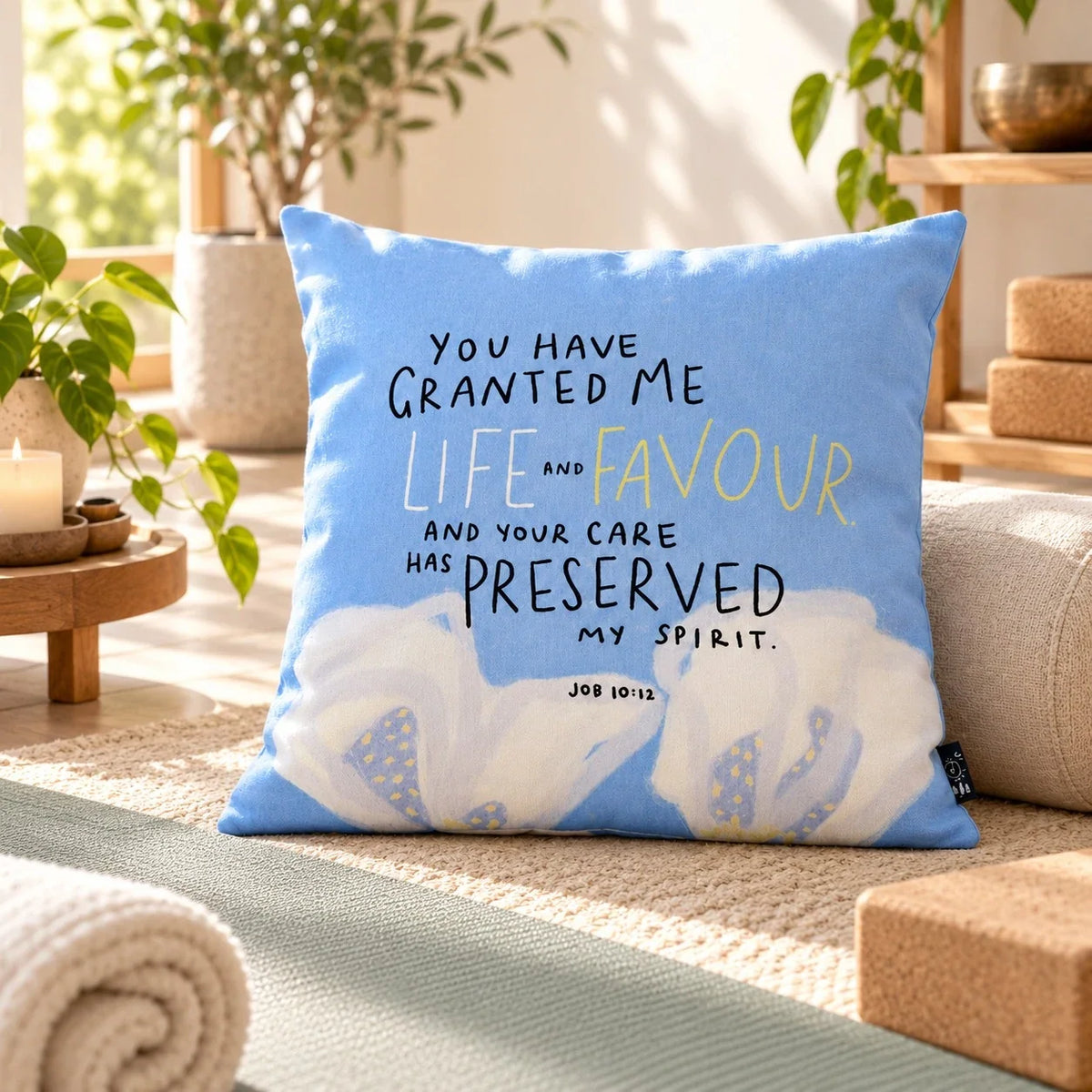 You Have Granted Me Life and Favour Christian blue cushion styled on a neutral sofa in sunlight.