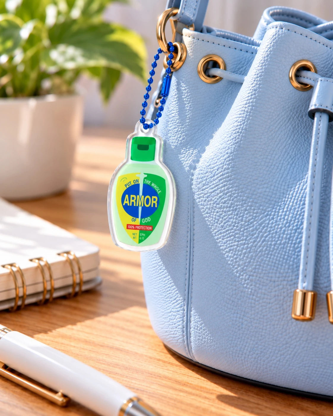 Armor of God hand sanitiser acrylic keychain on a light blue handbag