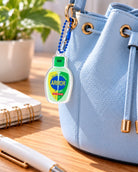 Armor of God hand sanitiser acrylic keychain on a light blue handbag