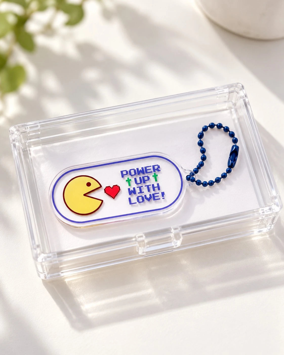 Power Up With Love pixel-style acrylic keychain displayed on a clear case