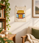 Bold Lion Balm small wall tapestry hanging in a cosy reading corner with books, trailing houseplant and armchair