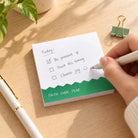 Faith Over Fear green and white sticky note pad with a handwritten encouragement checklist on a wooden desk