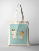 Faith based Tote Bag featuring a minimalist illustration of two figures, Jesus and a girl dancing set against a soft blue background. The design exudes a sense of peace and spirituality, encapsulated in a simple tote bag.