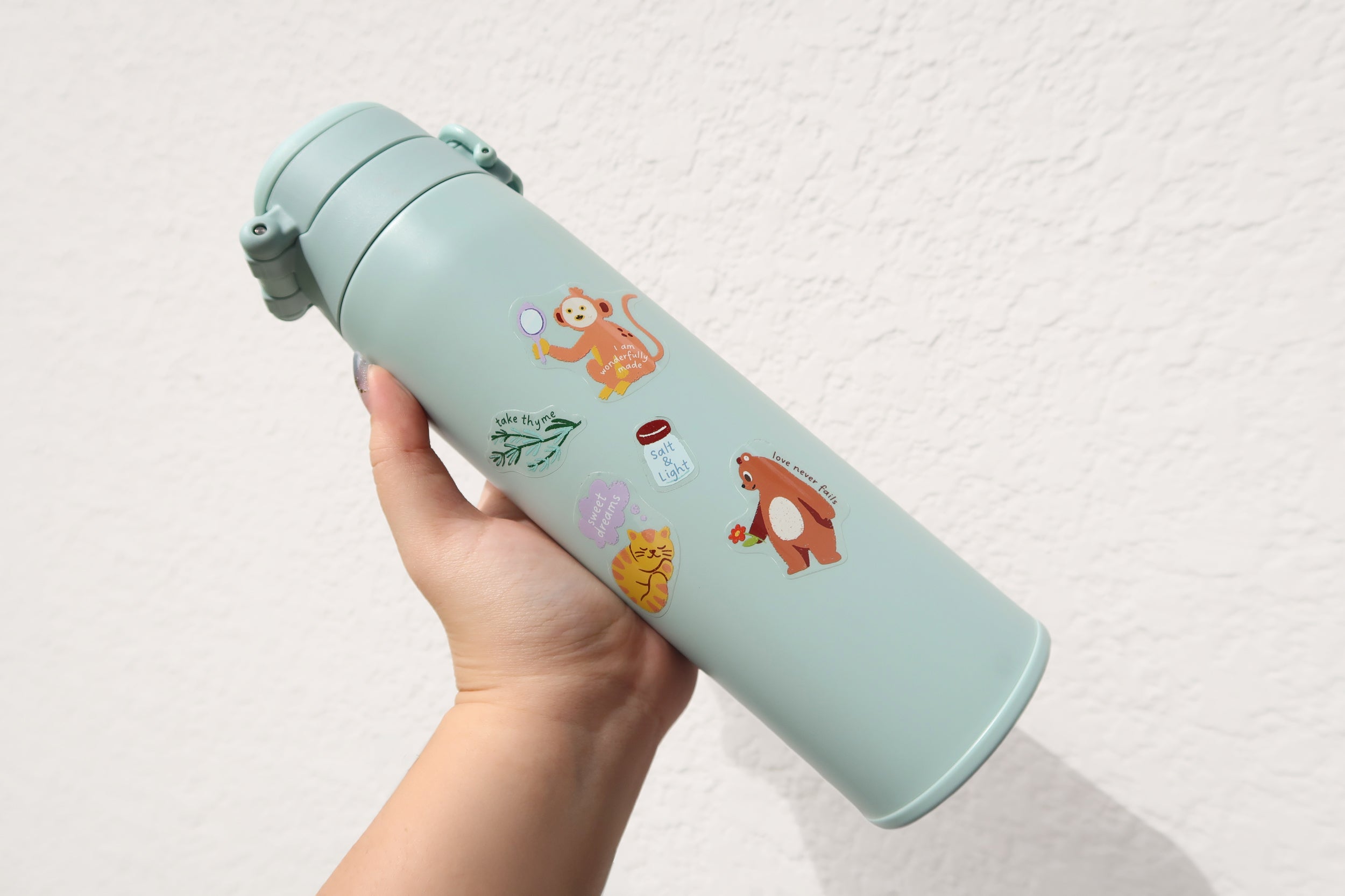 Reusable water bottle decorated with everyday believer Christian stickers, showing cute faith-inspired designs perfect for travel and daily use