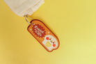 Brown embroidered keychain with a cheerful bread character and the text 'Bread of Life'.