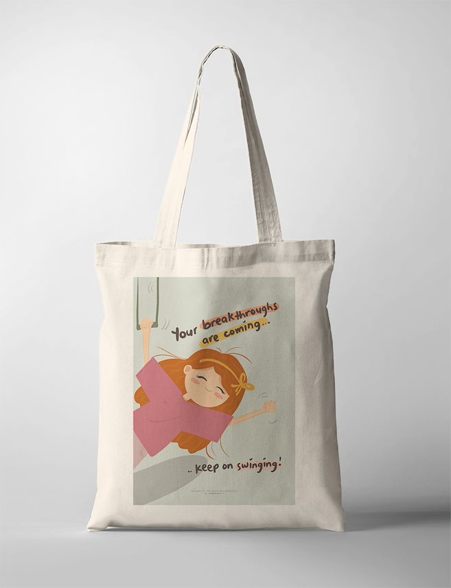 Inspirational Christian Tote Bag of a smiling girl swinging joyfully with the words: 'Your breakthroughs are coming... keep on swinging!' The artwork encourages perseverance and hope through faith.
