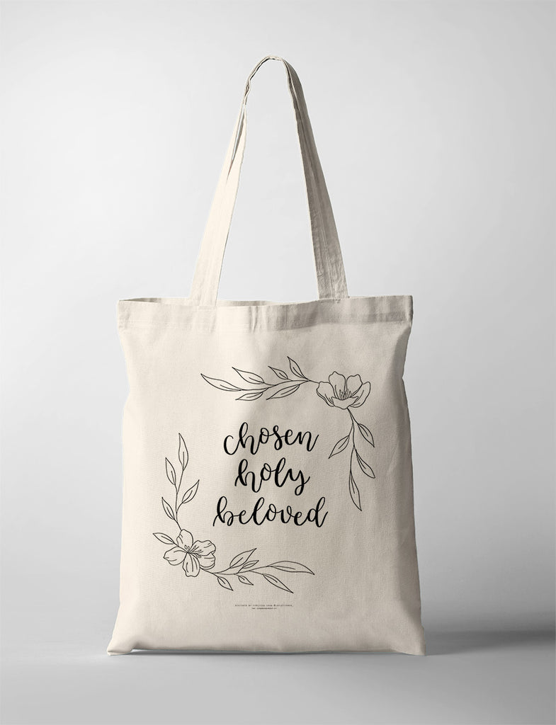 Beige tote bag featuring 'Chosen Holy Beloved' text with floral accents in black ink.