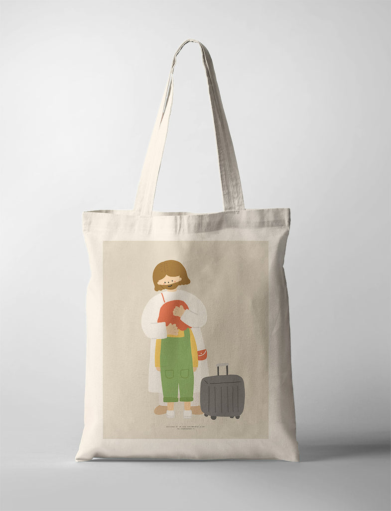 Canvas tote bag featuring an illustration of a comforting embrace between two characters, symbolizing love, protection, and travel readiness with a suitcase.