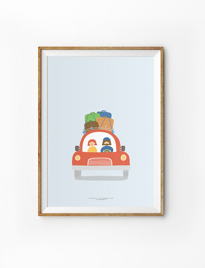 Framed artwork featuring a cheerful illustration of a red car with Jesus and a child inside, luggage stacked on top, set against a light blue background.