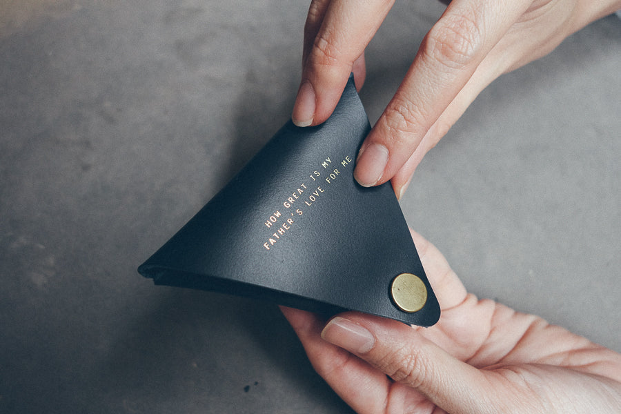 Christian leather coin pouch with compact button-close design.