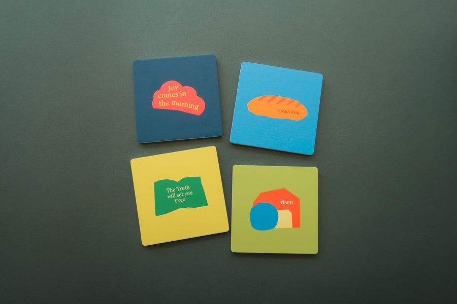 Divine Wooden Coaster Set: Colorful square coasters featuring Christian-inspired designs.