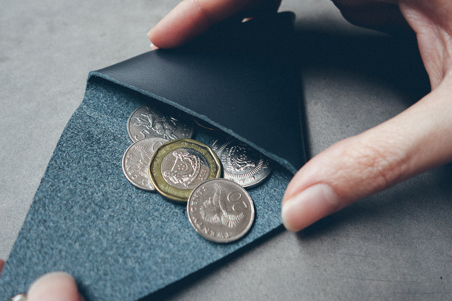 Midnight-blue leather coin pouch with minimalist compact design.