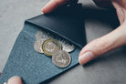 Midnight-blue leather coin pouch with minimalist compact design.