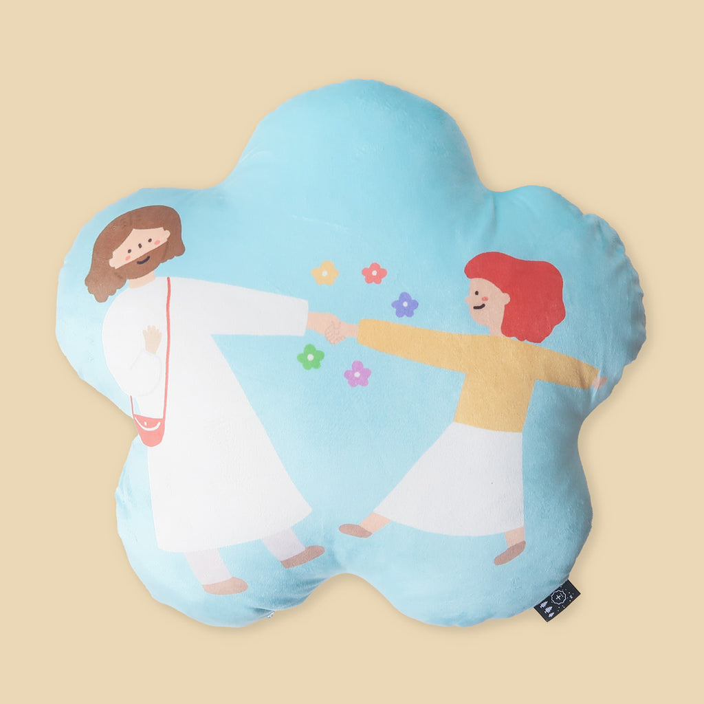 A soft, flower-shaped plush pillow showing a child joyfully dancing with Jesus, with bright colors and a heartwarming design.