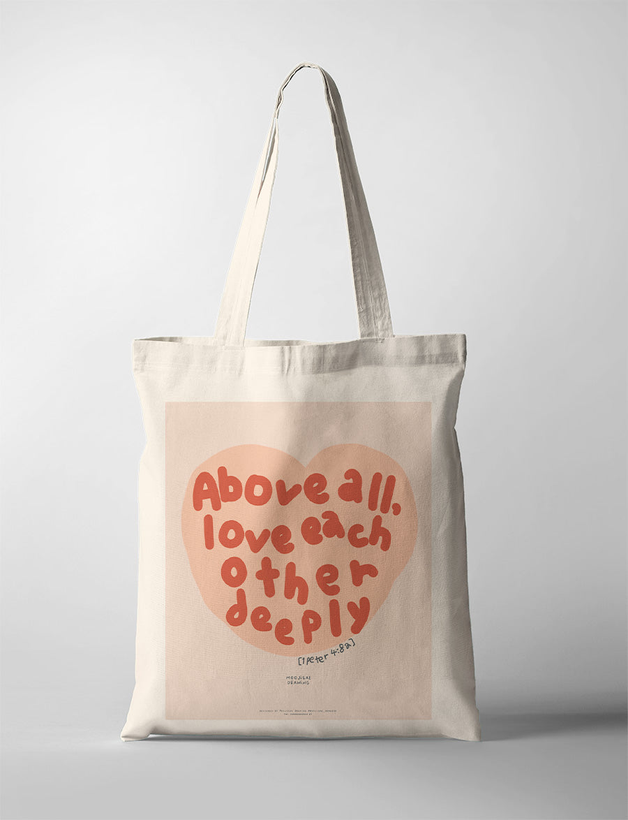 Christian canvas tote bag with “Above all, love each other deeply” typography inspired by 1 Peter 4:8, created in collaboration with Moojigae Drawing