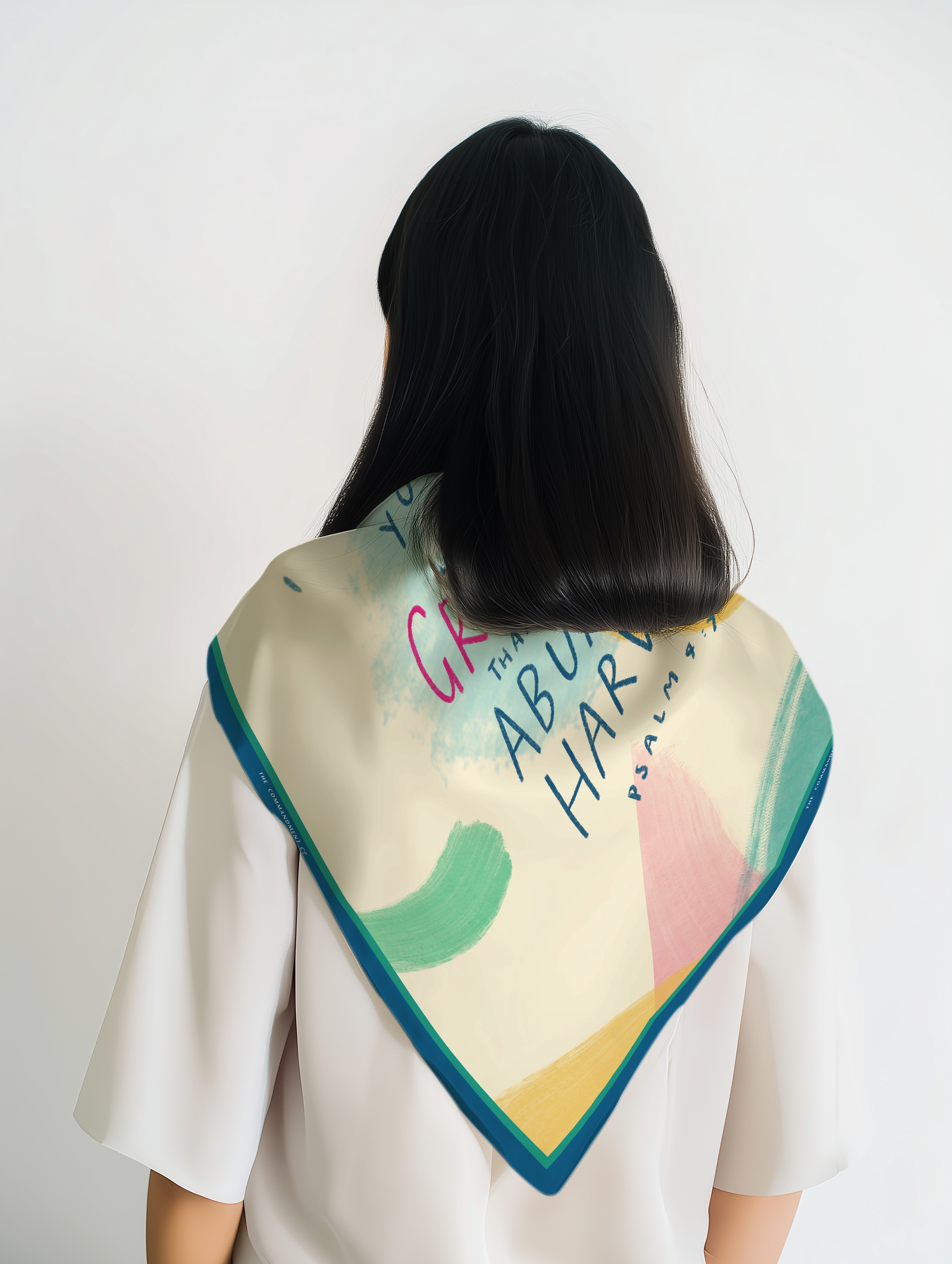 Abstract pastel scarf with teal border worn over a white top, shown from the back with colorful brushstrokes and script typography – a faith-forward accessory by The Commandment Co.