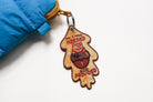 Back view of embroidered Christian keychain with “All I Have Needed God Provided” text and cute animal illustration.