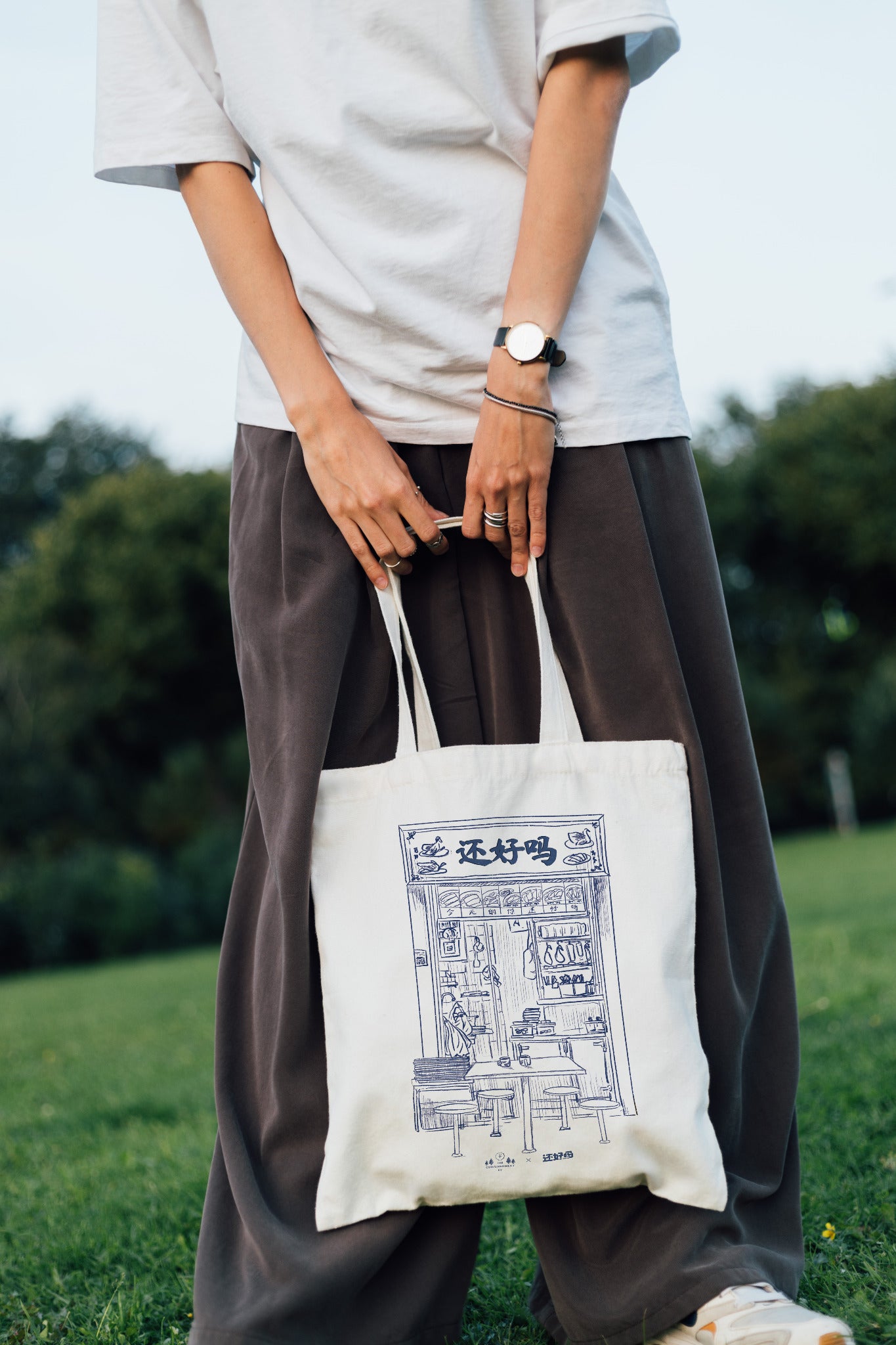 Person carrying the Are You Okay Food Stall kopitiam tote bag outdoors
