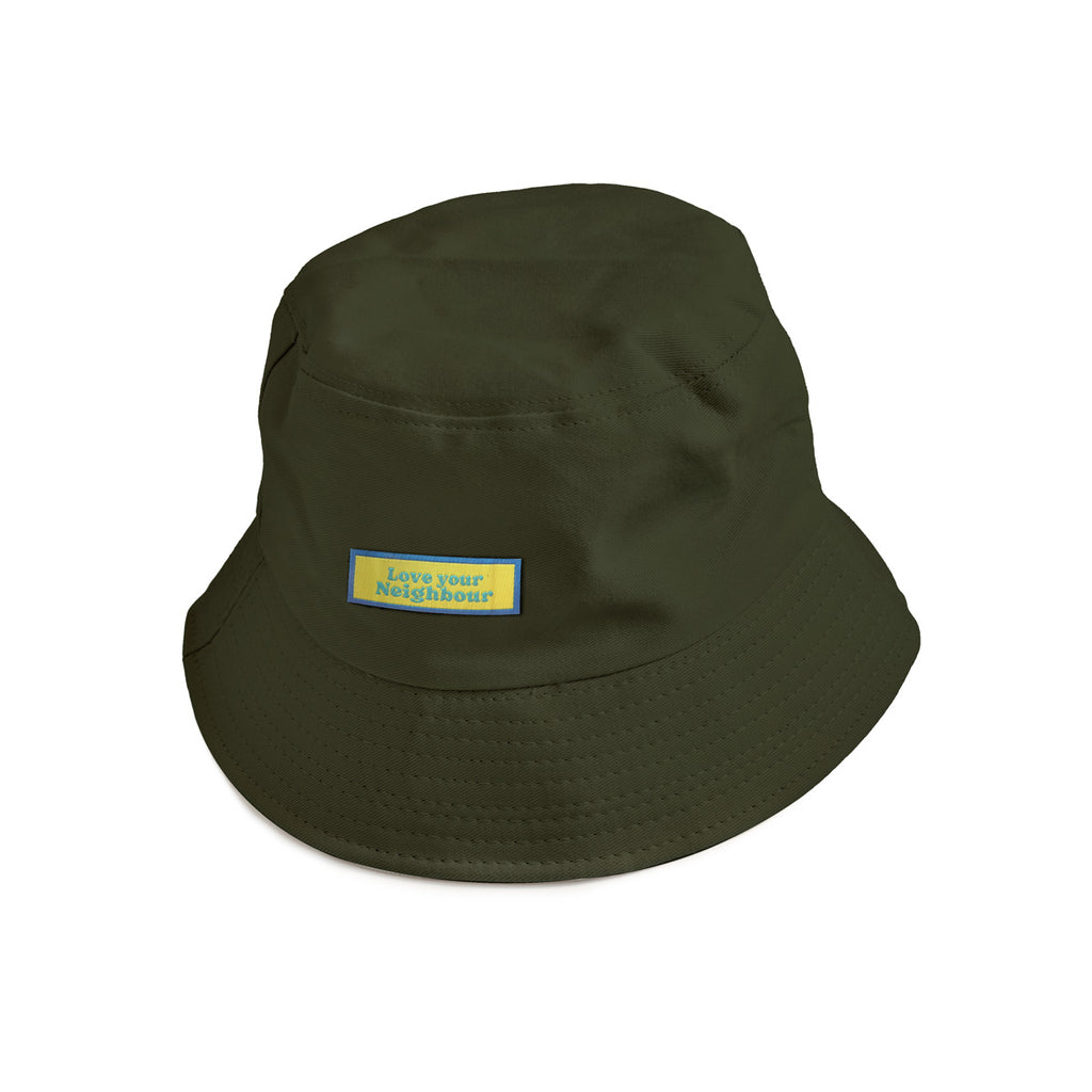 An army green bucket hat with a blue and yellow patch reading "Love Your Neighbour," a Christian-themed accessory promoting kindness and faith.