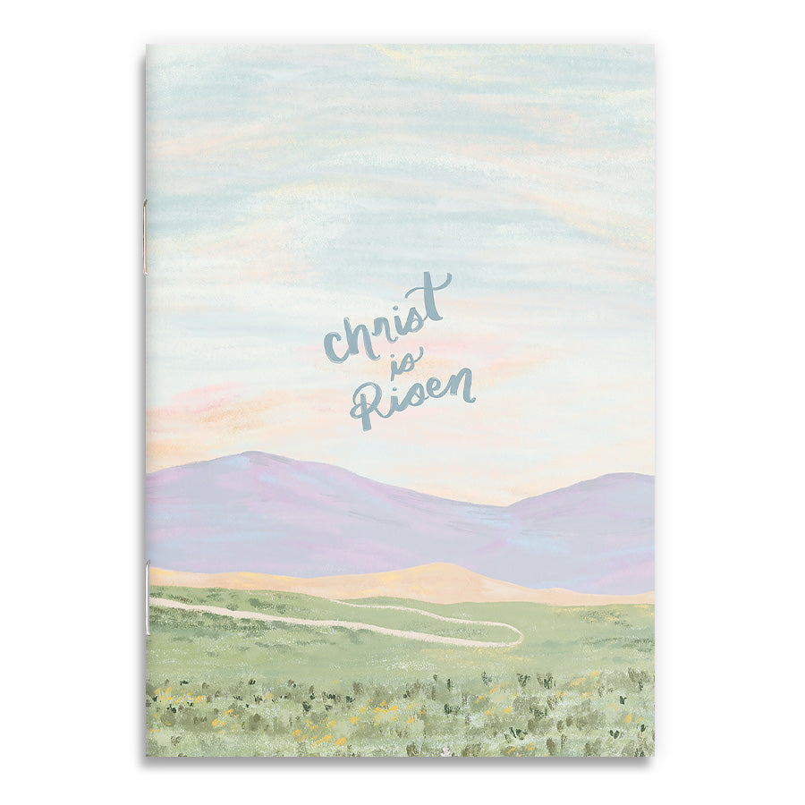 Front cover of A6 notebook with a pastel landscape and 'Christ is Risen' message, designed as a faith-inspired Easter gift