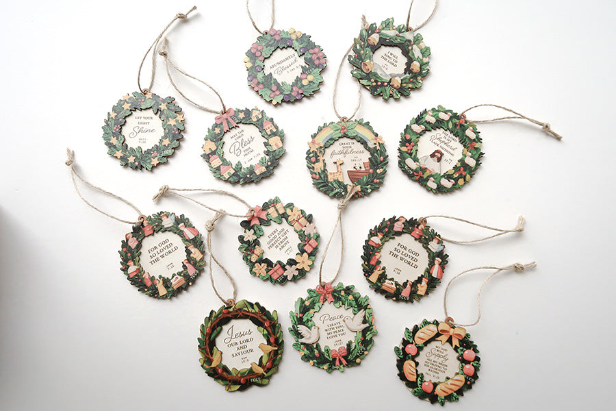 Assorted Christian Christmas wreath ornaments featuring Bible verses, displayed on a white background, showcasing festive and colorful designs.