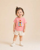 Smiling toddler wearing the pink Beloved Juice Christian kids’ T-shirt