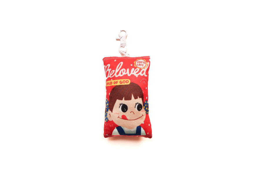 Beloved Milk Candy Girl plushie keychain with red candy packet design and Child of God detail