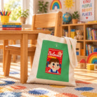 Beloved Milky Candy Galatians 3:26 Christian canvas tote bag leaning against a child's wooden classroom chair