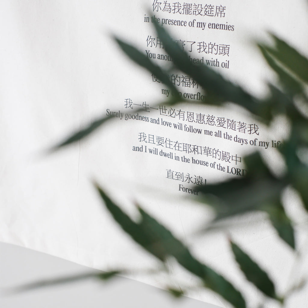 Close-up view of Psalm 23 Bible verse wall art printed on cotton fabric, featuring scripture text in Chinese and English with a leafy foreground.