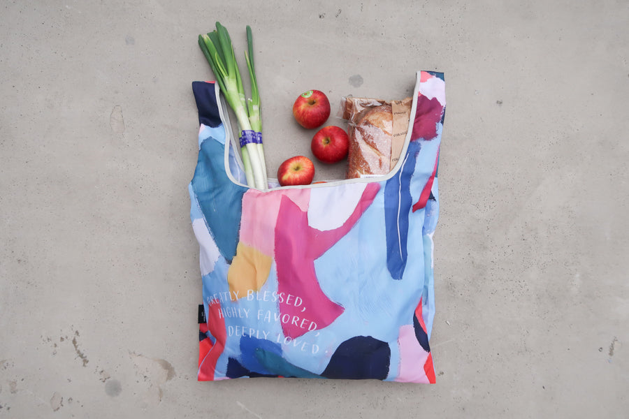 Foldable reusable shopping 
bag with Bible verse 
"Greatly Blessed, Highly 
Favored, Deeply Loved," 
filled with groceries, ideal 
for Christian gifts and 
Christian gift stores. 