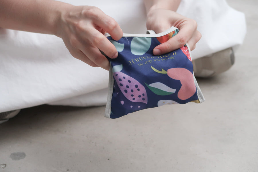 Foldable Bible verse 
shopping bag with fruit 
design being packed into 
a small pouch, ideal for 
Christian gifts and 
Christian gift store 
customers. 