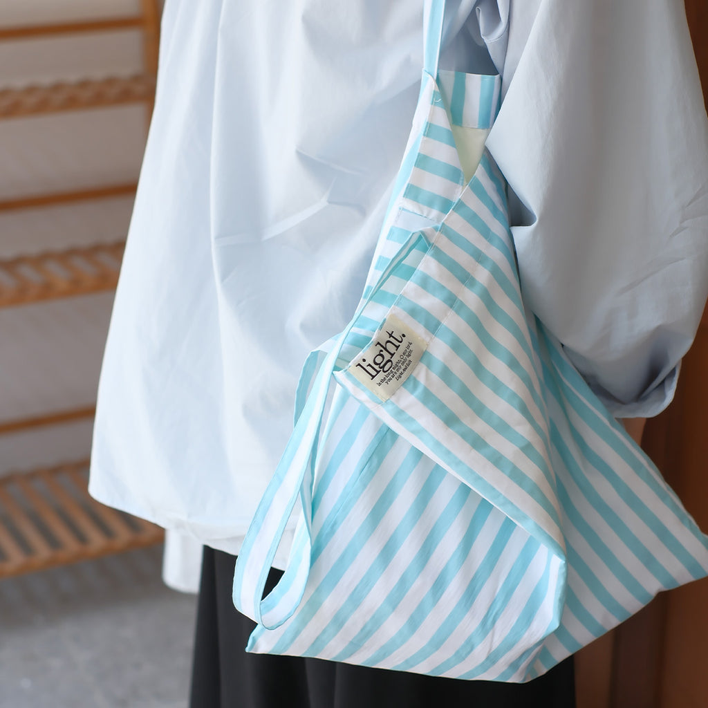 Close-up of a blue striped cotton tote bag, an eco-friendly reusable shopping bag that is both durable and stylish.