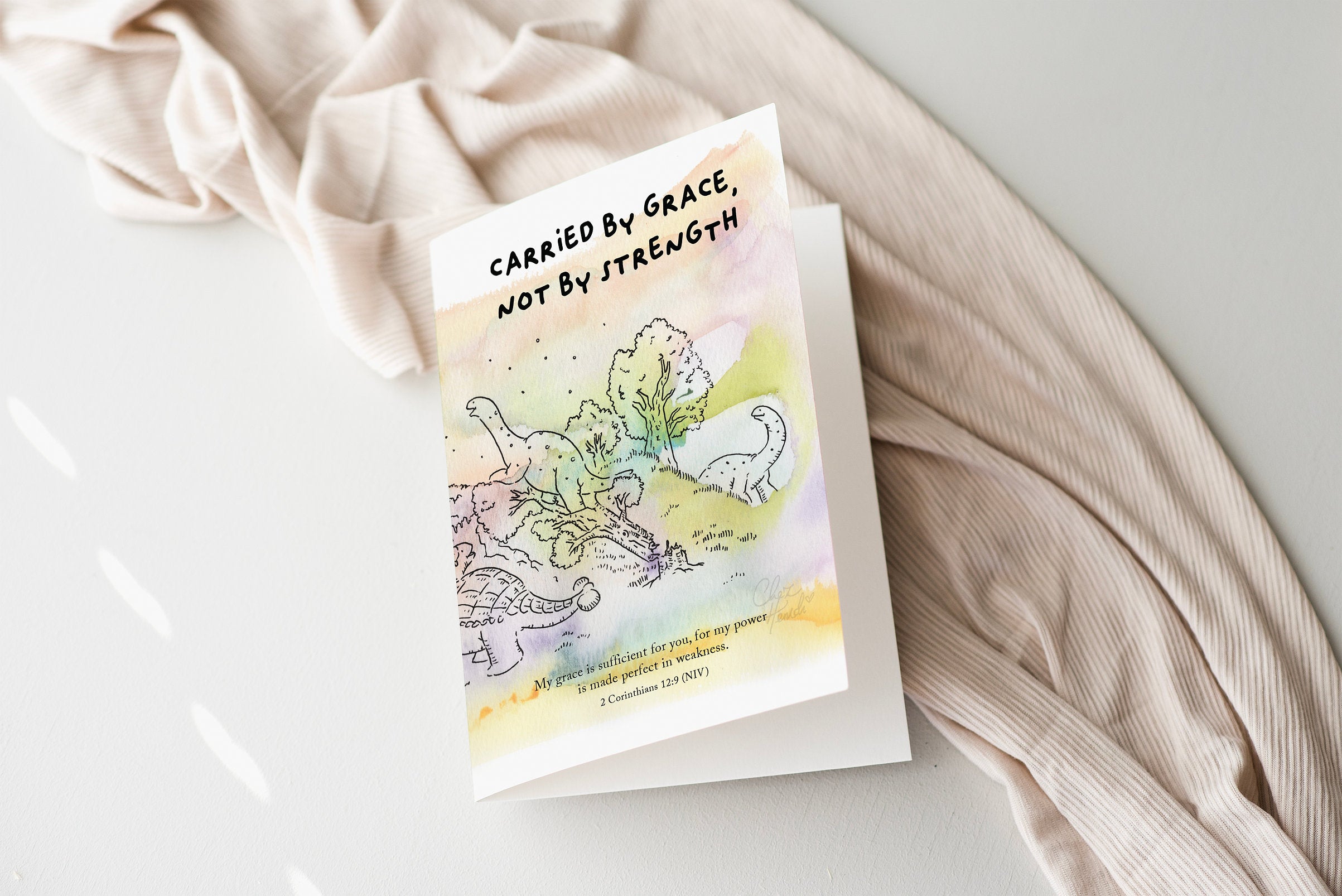 ChezHemdi dino greeting card with ‘Carried by Grace, Not by Strength’ verse – Christian encouragement stationery from The Commandment Co