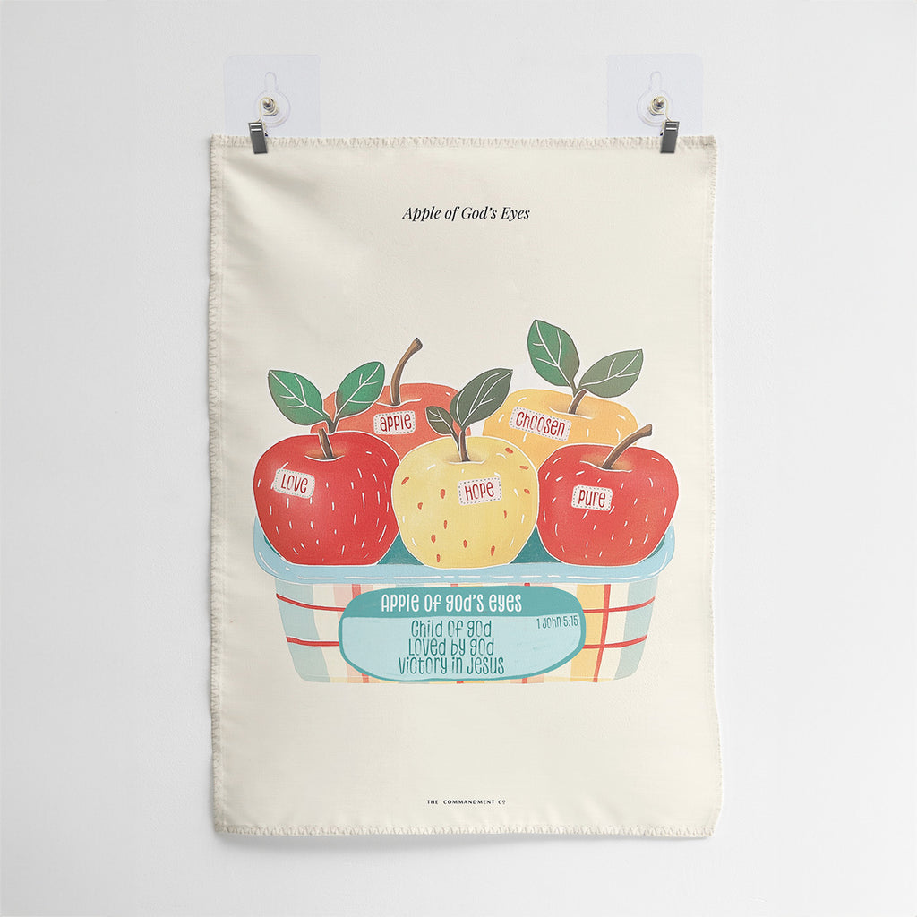 Wall tapestry featuring 'Apple of God's Eyes' design with apples labeled 'Love,' 'Hope,' 'Chosen,' and 'Pure,' alongside the message 'Child of God, Loved by God, Victory in Jesus,' inspired by 1 John 5:15.