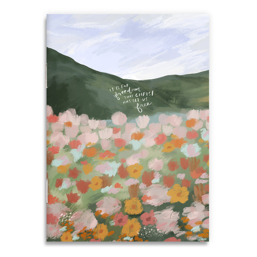 Front cover of 'Freedom in Christ' A6 notebook featuring an illustrated field of vibrant flowers and the inspirational message 'It is for freedom that Christ has set us free.'