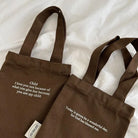 Two brown canvas drink carrier bags featuring Child I Love You and Wonderful Day faith-inspired text designs