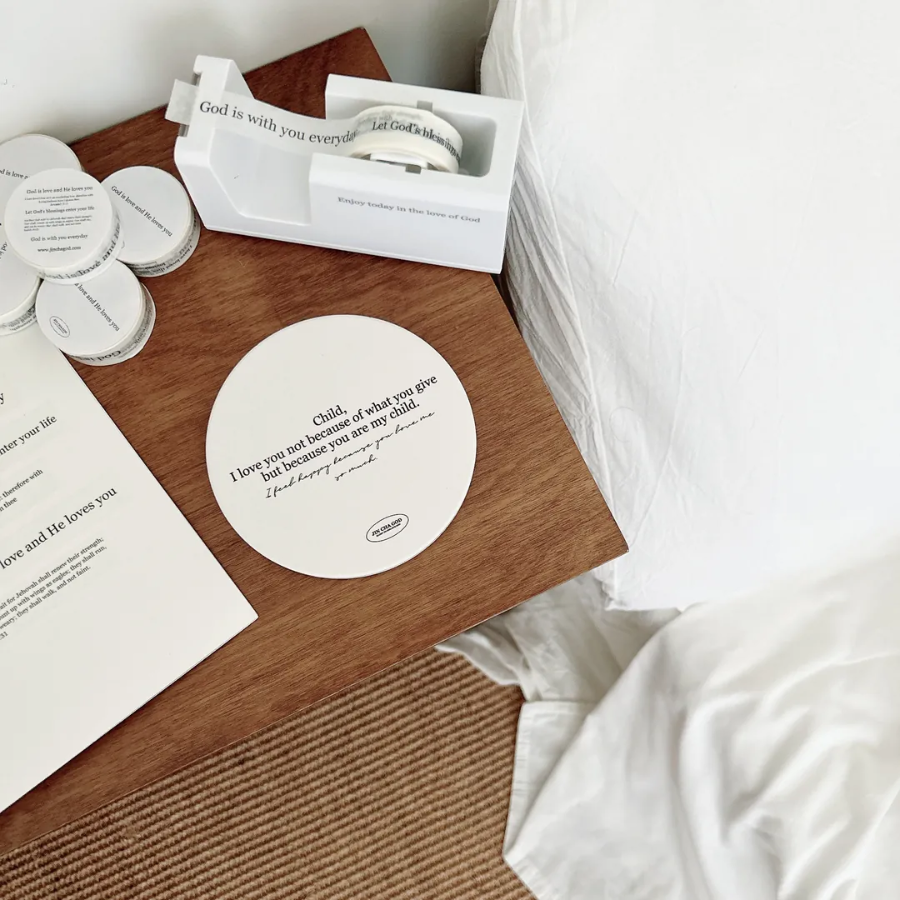 Front view of Christian ceramic coaster on wooden table featuring Bible verse design