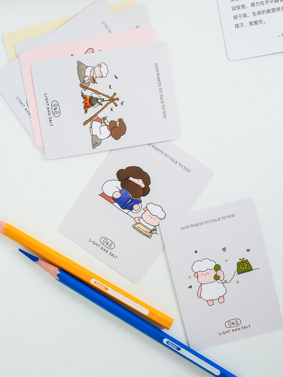 Christian mini encouragement cards featuring playful Jesus illustrations styled with pencils in a clean minimal flatlay setup