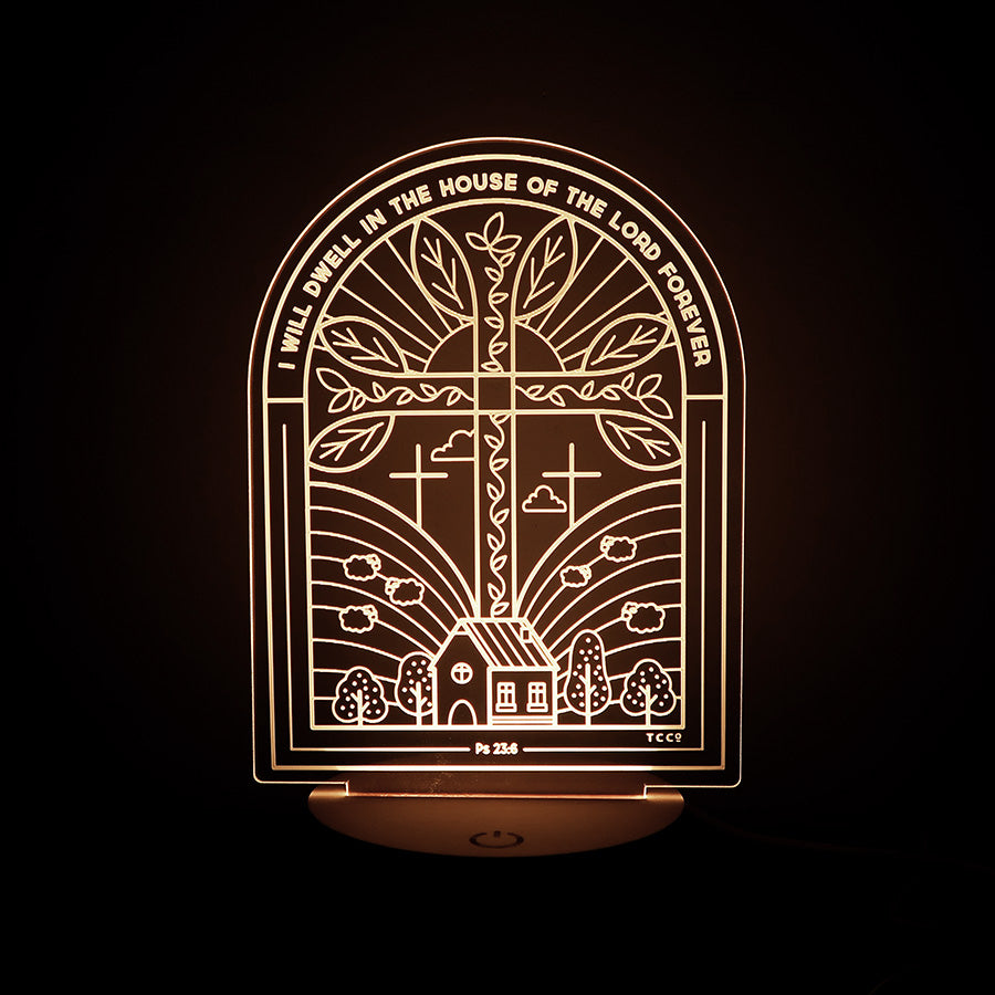 Christian LED lamp featuring an arch window design with a cross, a house, trees, and the verse from Psalm 23:6: 'I will dwell in the house of the Lord forever.'