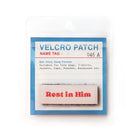 Light pink Velcro tag with red text 'Rest in Him,' a faith-based embroidered patch for Christian apparel and accessories.