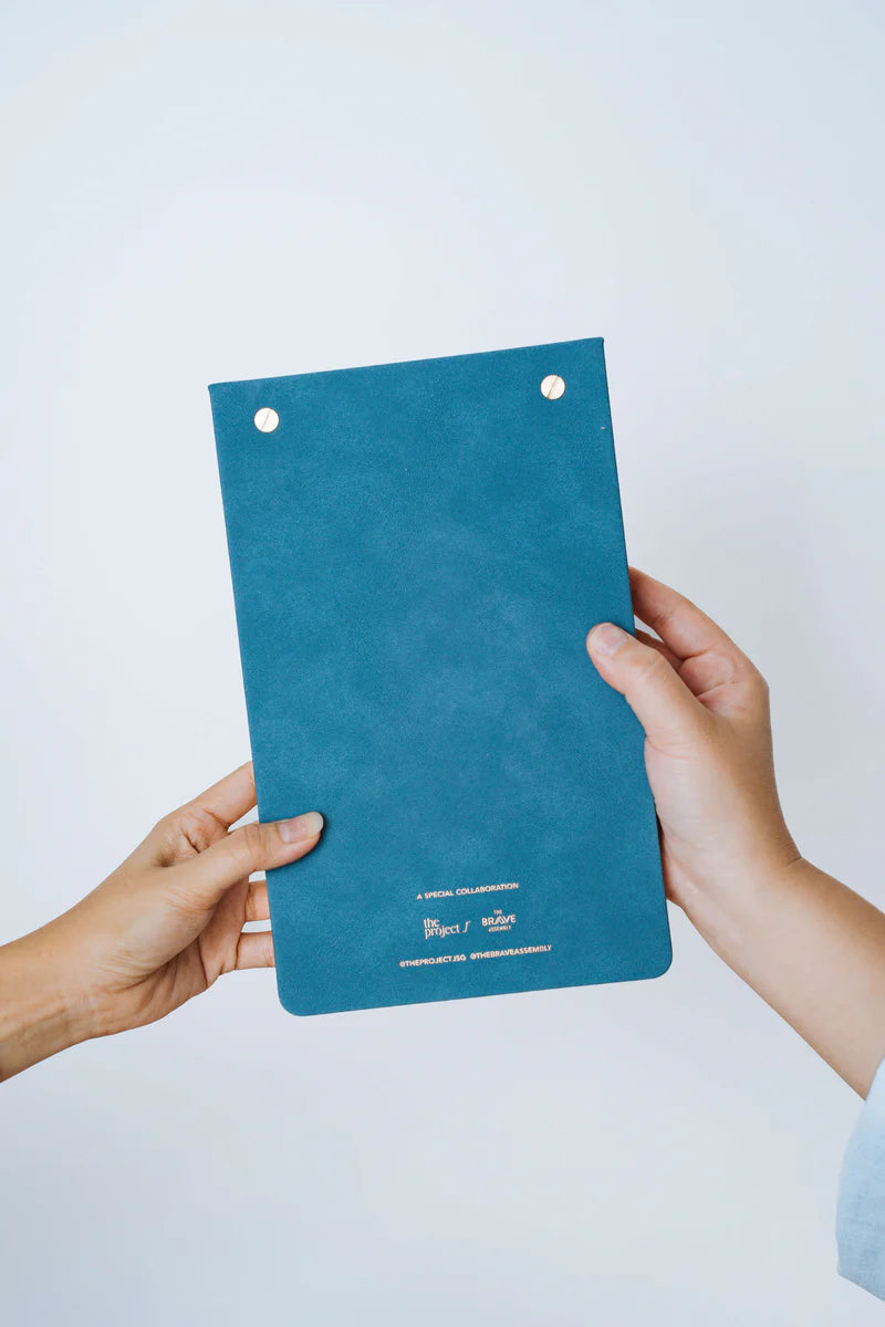 Back view of The Project J Christian notepad in blue, featuring a soft textured cover and special collaboration details, perfect for uplifting and faith-inspired daily planning.