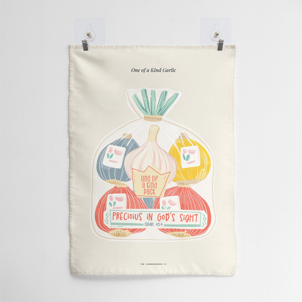 Wall tapestry featuring a bundle of colorful garlic labeled 'One of a Kind Pack' with the text 'Precious in God's Sight' and the Bible verse Isaiah 43:4.