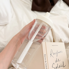 Christian water bottle with the phrase “Enjoy today in the love of God” printed on it, placed on a table with an open Bible and a pastry, inspirational gift from The Commandment Co.