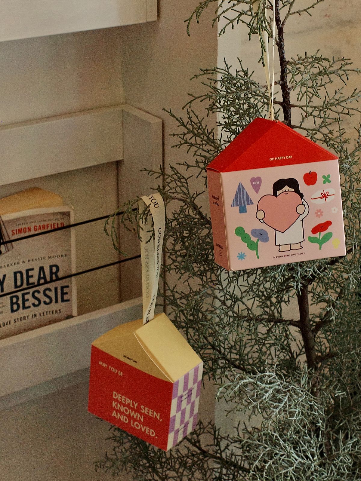 House shaped gift box hanging on tree as festive decoration and Christmas gift packaging