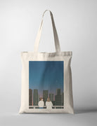 Christian tote bag with city skyline artwork and Jesus and a person, modern design symbolizing faith in daily life.