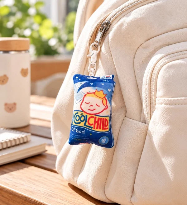 Cool Child of God Fever Patch soft plushie keychain clipped to a cream backpack