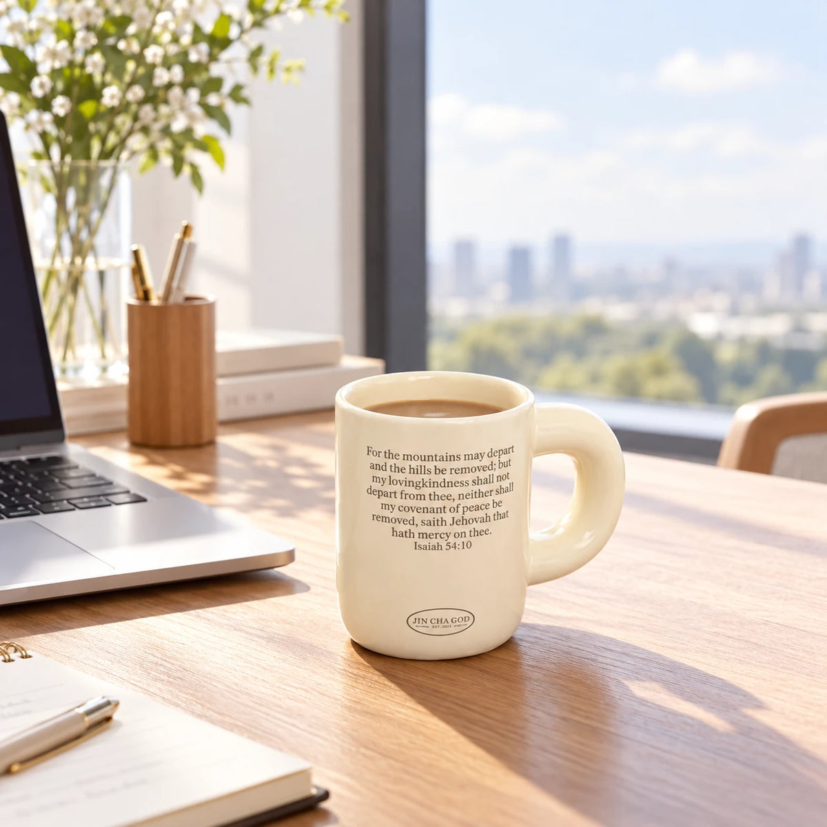 Covenant of Peace ceramic Bible verse mug filled with coffee on a bright wooden desk beside a laptop