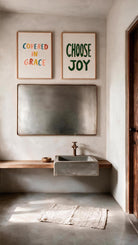 Covered in Grace Christian poster styled beside the separately sold Choose Joy poster in a warm neutral bathroom
